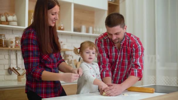 Mladí rodiče s dcerou batole bavte se společně hnětení těsta — Stock video