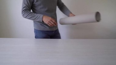 Tamirci yeni duvar kağıdı rulo tablo kapalı üzerinde işaretleme için hazırlanıyor
