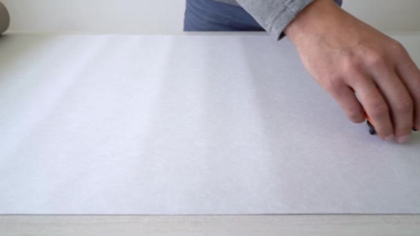 Primer plano manos masculinas medición de rollo de papel pintado con cinta métrica en la mesa interior — Vídeo de stock