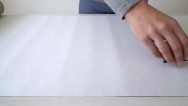 Primer plano manos masculinas medición de rollo de papel pintado con cinta métrica en la mesa interior — Vídeo de stock