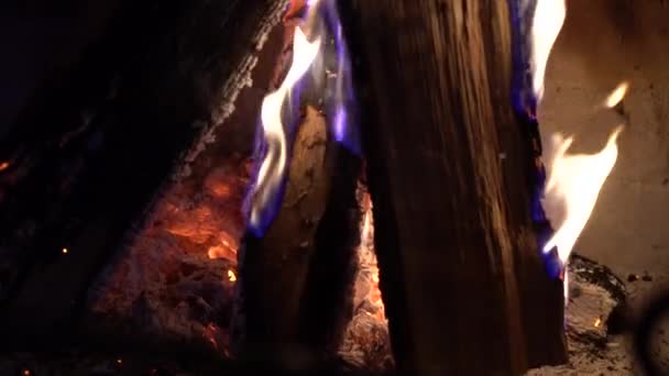 暗闇の中で伝統的なれんが造りの暖炉で燃えている木のクローズ アップ — ストック動画