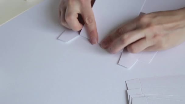 Крупный план женщины руки складывая бумажный шаблон — стоковое видео