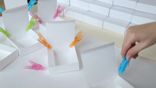 Mulher mãos remoção closeup closeup clothespins de caixa de papel — Vídeo de Stock