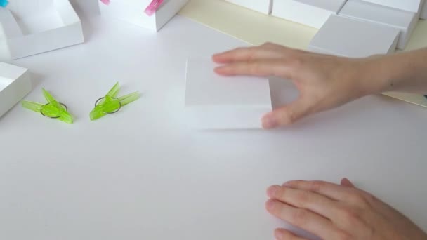 Mujer manos quitando pinzas de la caja de papel primer plano — Vídeo de stock
