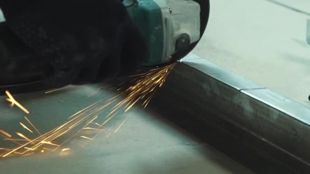 Крупный план искр от круглошлифовального станка резки металлического профиля в цехе — стоковое видео