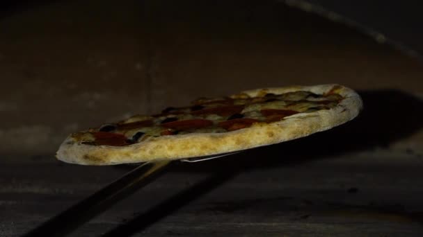 在传统烤箱内的铁铲上举行比萨饼的特写镜头在传统的烤箱在慢动作 — 图库视频影像