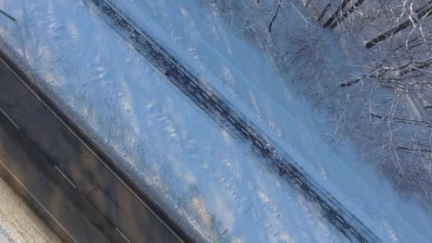 Aerial of people jogging on path near city road in winter — Stock Video