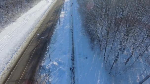 Антенна Бега Людей Тропинке Между Городской Дорогой Лесом Зимой Верхний — стоковое видео