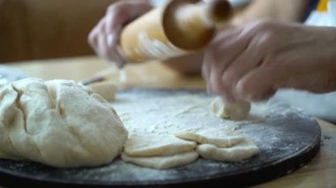 Eller üst düzey kadın hamuru oklava closeup ile çalışırken parçaları