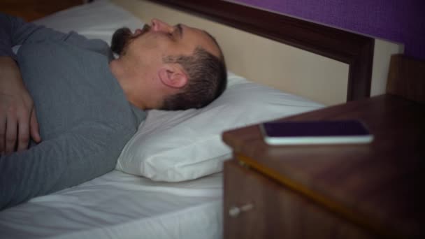 Mladý vousatý muž probudil ve své posteli — Stock video