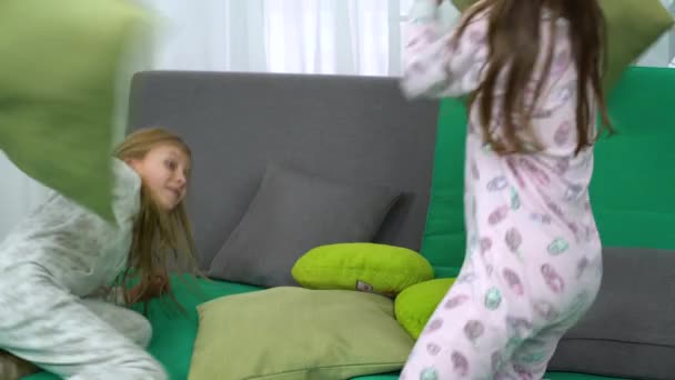 소파에 베개로 싸우는 두 귀여운 어린 소녀 — 비디오