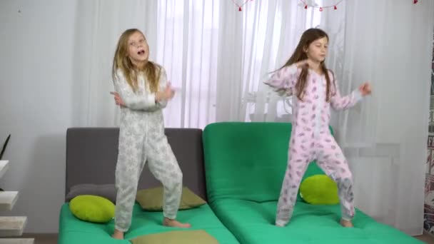 Söta flickor i pyjamas Dans på soffan — Stockvideo