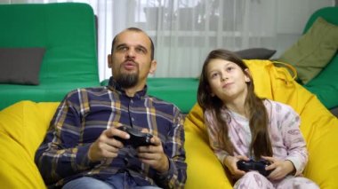 Baba ve kızı evde gamepad ile oynamak