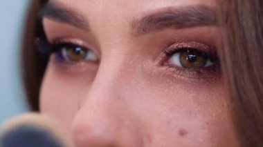 Genç esmer kadın yüz pudrası yavaş uygulama closeup