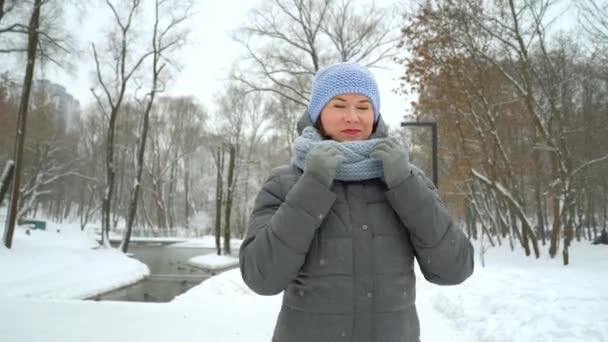 Взрослая женщина, гуляющая в зимнем парке — стоковое видео