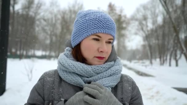 Triste mujer adulta caminando sola en el día nevado en invierno primer plano — Vídeos de Stock