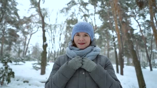 Щаслива доросла жінка, що йде в зимовому парку — стокове відео