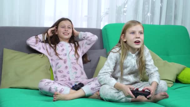 Pequeños jugadores jugando con almohadillas de juego en el sofá — Vídeos de Stock