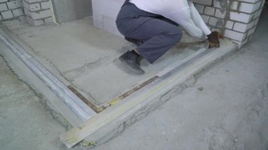 İnşaat alanında ölçüm standardı olan biçimlendirme yapıyor inşaat işçisi