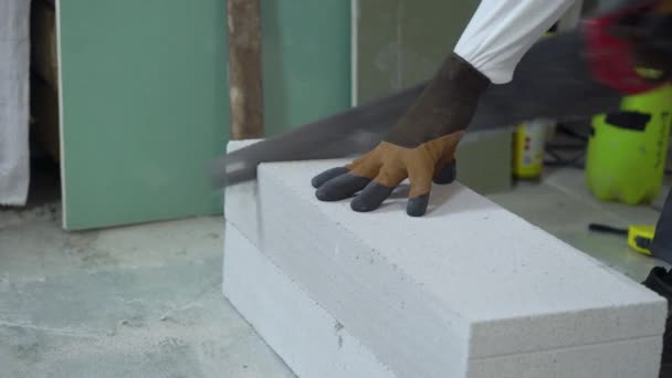 Bouwer zagen belucht betonnen blok met hand zag — Stockvideo