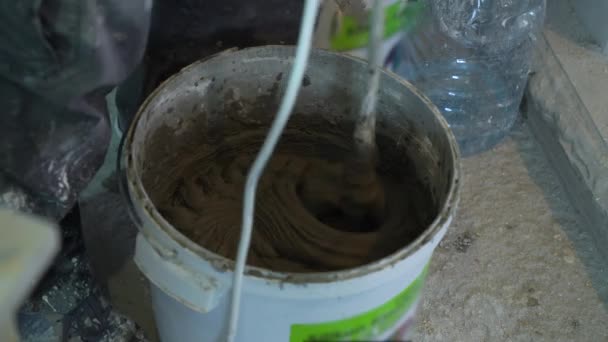 Close-up de solução adesiva de mistura em balde no canteiro de obras — Vídeo de Stock