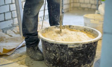 İnşaat işçisi sıva çözüm elektrikli karıştırıcı ile karıştırma