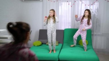 Üç sevimli kız koltukta dans pijama