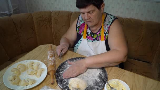 Пожилая женщина готовит на кухне — стоковое видео