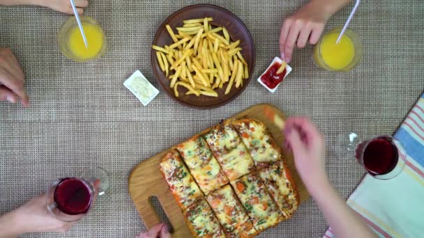 Bovenaanzicht van familie eten van pizza en frietjes — Stockvideo