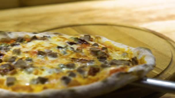 Closeup of serving freshly baked Italian pizza on wooden cutting board — Stock Video