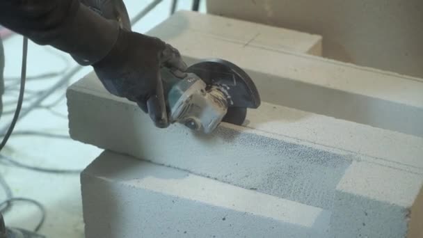 Nahaufnahme eines Bauarbeiters, der Porenbeton-Block mit Kreissäge zersägt — Stockvideo