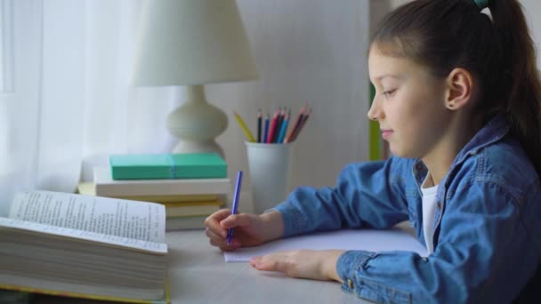 Petite fille faisant devoir à l'école à la maison — Video