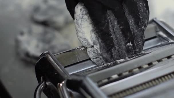 Closeup χέρι με γάντι βάζοντας μαύρο ζύμη σε μηχανή ζυμαρικών και τροχαίο — Αρχείο Βίντεο