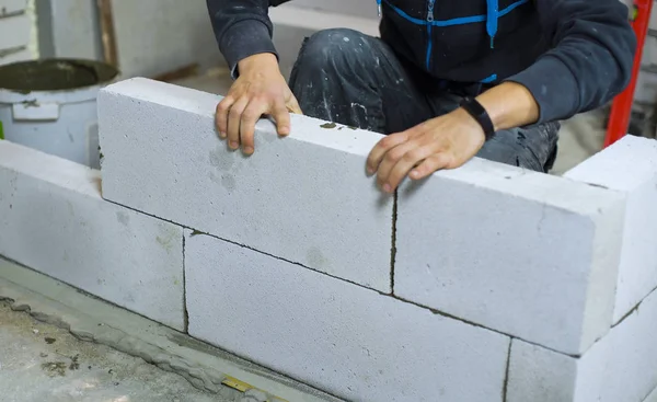Detailní záběr na tvůrce pokládání oxidem uhličitým betonových bloků v interiéru staveniště — Stock fotografie