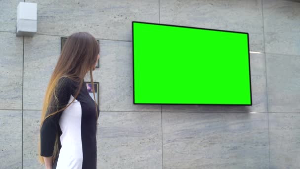 Unga leende affärskvinna ger presentation på stora grön skärm — Stockvideo