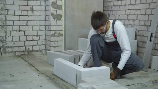Stavební dělník bití pórobetonu betonového bloku s gumovou paličku — Stock video