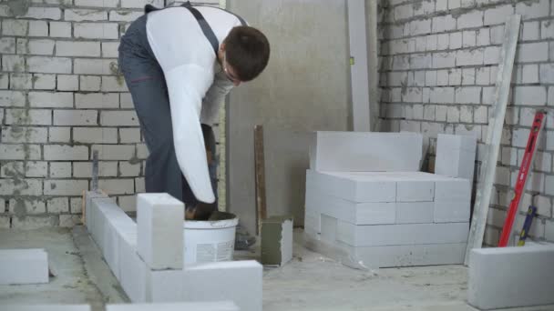 Builder kładzenie zaprawy na stronach Gazobeton beton blok z łopatką — Wideo stockowe