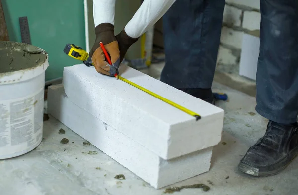 Tvůrce měří oxidem uhličitým betonového bloku s krejčovským metrem — Stock fotografie
