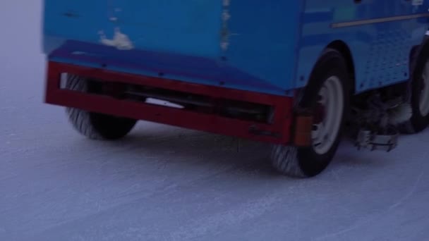 Resurfacing machine cleaning ice of open air skating rink in slow motion — Stock Video