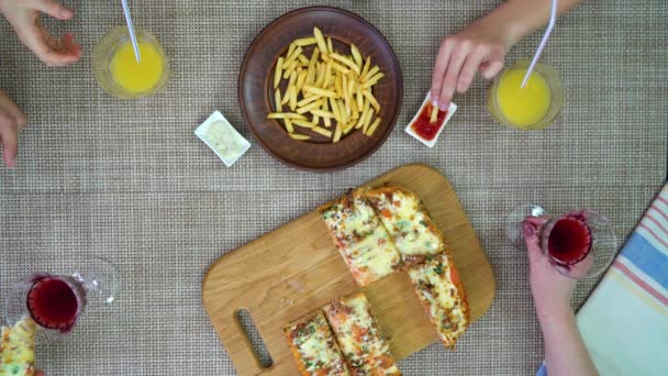 Comer pizza y papas fritas con la familia en casa vista superior — Vídeos de Stock