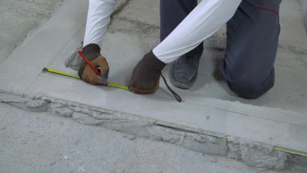 Builder measures distances with measuring tape and pencil at construction site — Stock Video