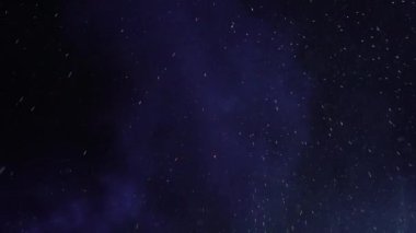 kar taneleri ve yangın kıvılcımlar vurgulanan tarafından gece gökyüzünde dönen projektör