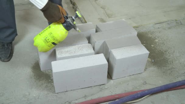 Travailleur de la construction humidifier blocs de béton aéré avec pulvérisateur d'eau — Video