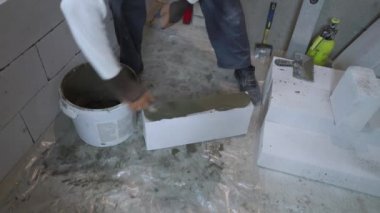 Oluşturucu yapışkanlı çözüm Gaz beton blok tarafına spatula ile koyar