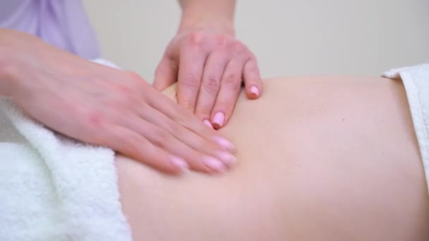 Primer plano de las manos femeninas haciendo masaje contra la celulitis en el abdomen de la mujer joven — Vídeo de stock