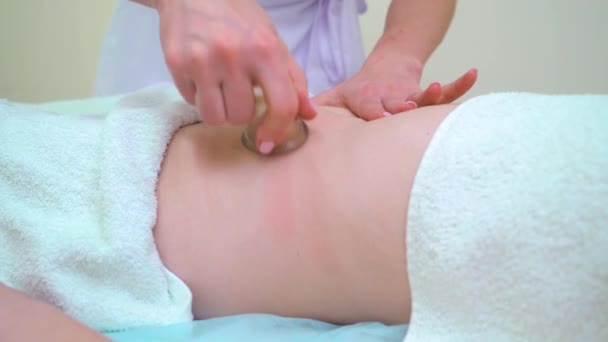 Close-up vrouwelijke handen masseren vrouw buik met vacuüm bekers — Stockvideo