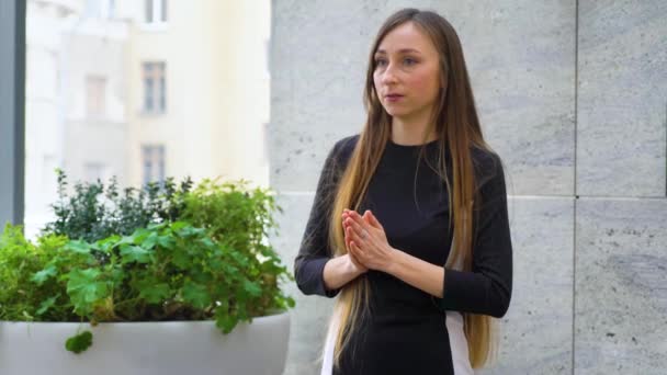 Junge Frau mit langen Haaren gestikuliert aktiv, während sie einen Stand-up-Vortrag hält — Stockvideo
