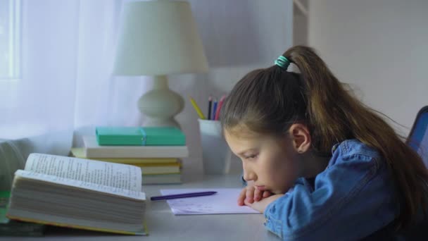 Triste chica de la escuela pone su cabeza en las manos y mira en la cámara — Vídeos de Stock