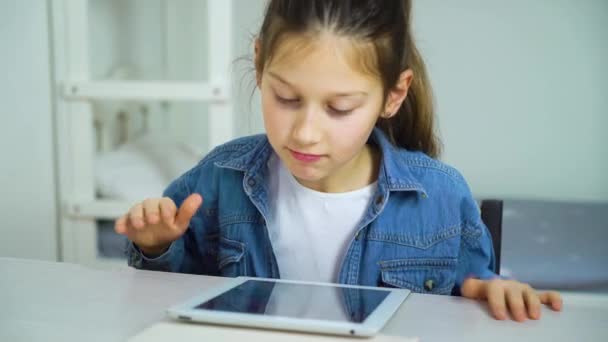 Niña se emociona con imágenes en la pantalla de la tableta — Vídeos de Stock