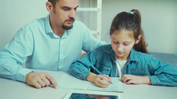 Menina está prestes a chorar enquanto fazendo lição de casa em conjunto com o pai rigoroso — Vídeo de Stock